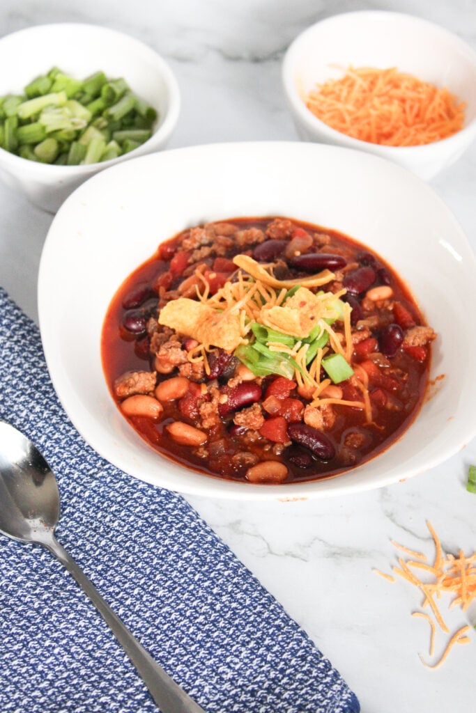 Warm up with this easy homemade beef chili recipe! With ground beef, beans, tomatoes, and spices, this hearty one-pot chili is ready in 45 minutes.