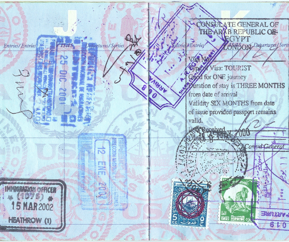 An open passport page filled with various international entry and departure stamps from the UK, USA, and Egypt, highlighting a history of global travel