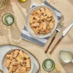 A bowl of rigatoni pasta with a creamy tomato and sausage sauce served on a blue and white striped napkin for a quick weeknight dinner.