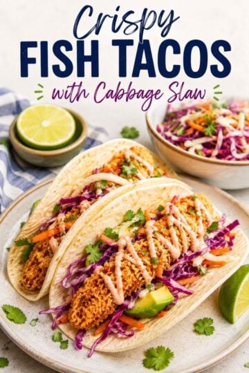 Crispy fish tacos with cabbage slaw, avocado, and creamy sauce in flour tortillas.